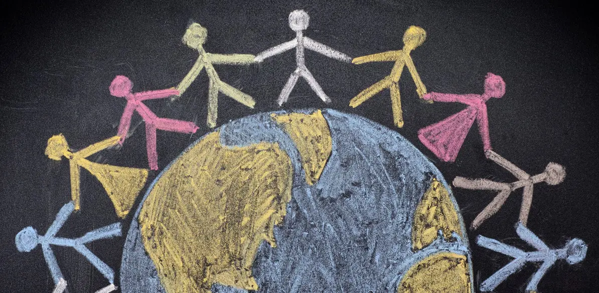 Sé colaborador solidario Dibujo infantil con tizas de colores sobre pizarra representa figuras humanas tomadas de la mano alrededor del planeta Tierra. Tonos azules, amarillo, rosa y blanco simbolizan una acción social global que promueve la solidaridad, la unión y la colaboración entre culturas.
